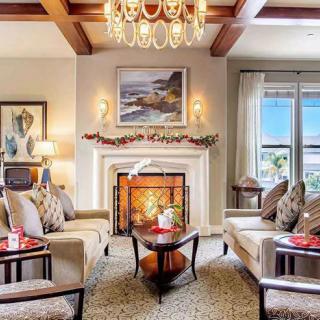 A beautifully decorated living room featuring a cozy fireplace, elegant chandelier, and comfortable seating.