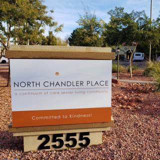 A sign for North Chandler Place with an address of 2555, located in a landscaped outdoor setting.