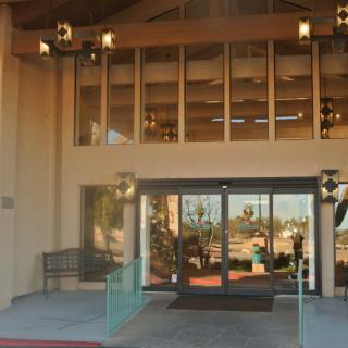 A modern building entrance with glass doors and outdoor lighting.