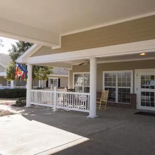 A cozy building entrance with a porch and flags.
