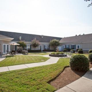 A well-maintained courtyard with a lawn, pathways, and outdoor seating.
