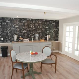 A modern kitchen dining area featuring a round table, chairs, and a chalkboard wall.