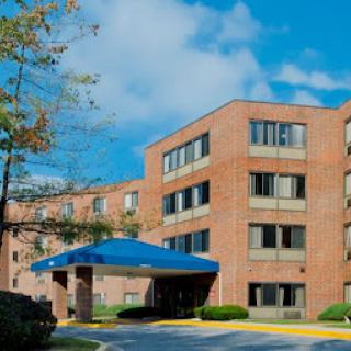 A welcoming view of a modern brick building under a clear blue sky.