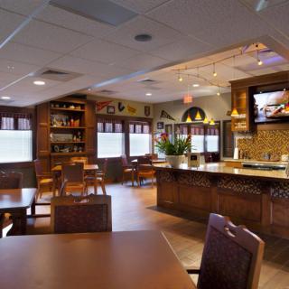 An empty restaurant interior with wooden furniture and warm lighting.