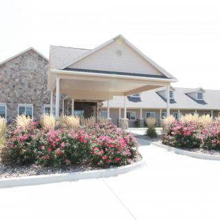 A building entrance with landscaped flower beds and a covered porch.