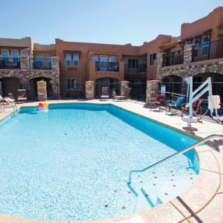 An inviting outdoor pool area at a resort with surrounding accommodations.