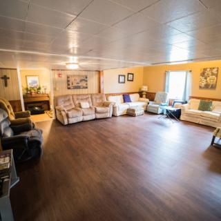 A spacious living room with multiple sofas and a warm, cozy atmosphere.