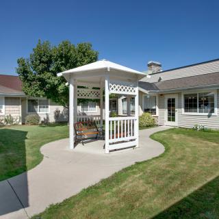 A peaceful courtyard with a gazebo and well-maintained lawn on a sunny day.