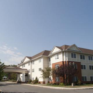 A residential building with a covered entrance under a clear blue sky.