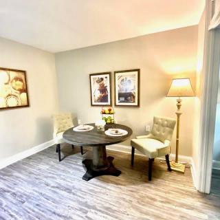 A cozy dining area featuring a round table, two chairs, and warm lighting.