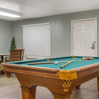 A cozy game room featuring a pool table and seating area.
