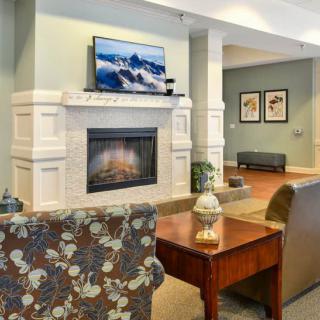 A cozy living room with a fireplace and a television above it.