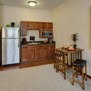 Cozy kitchenette with wooden cabinets and a small dining area.