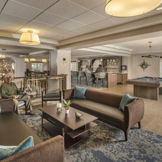 A cozy and modern lounge area featuring comfortable sofas, a pool table, and stylish lighting.