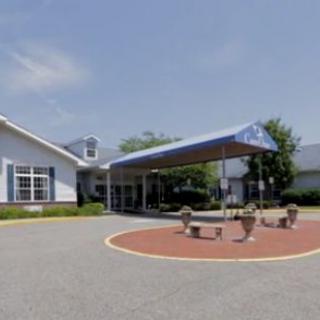 A building with an awning over a seating area on a clear day.