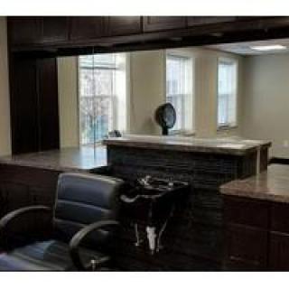 A modern hair salon featuring a sleek barber chair and large mirrors.
