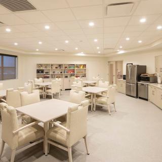 Modern kitchen and dining area with tables, chairs, and appliances.
