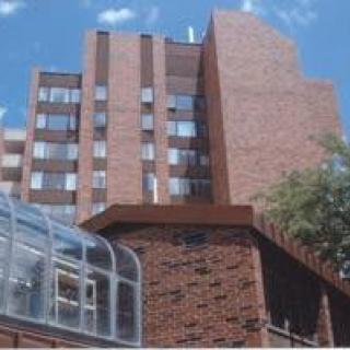 A brick building with multiple windows under a clear blue sky.
