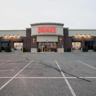 A retail store entrance with a spacious parking lot in front.