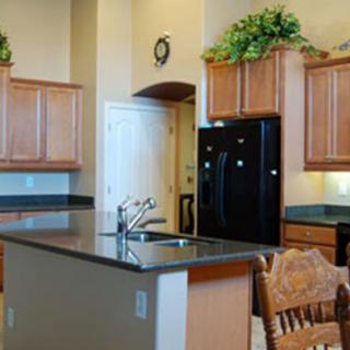 A modern kitchen with a central island and wooden cabinets.