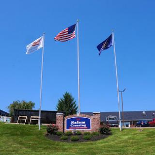 Flags waving proudly in front of a building under a clear blue sky.