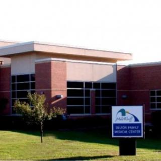 A medical facility with a brick exterior and a sign in front.