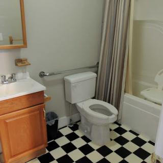 A compact bathroom featuring essential amenities including a toilet, sink, and shower.