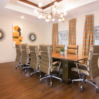 A modern conference room featuring a wooden table surrounded by stylish chairs and decorative elements.