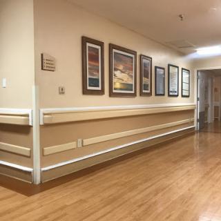 A serene hallway adorned with framed artwork, showcasing a warm and inviting atmosphere.