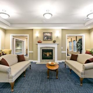 A cozy living room featuring two sofas, a central fireplace, and elegant decor.