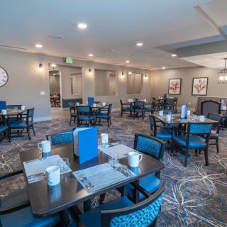 An indoor dining area with neatly arranged tables and chairs, featuring modern decor.