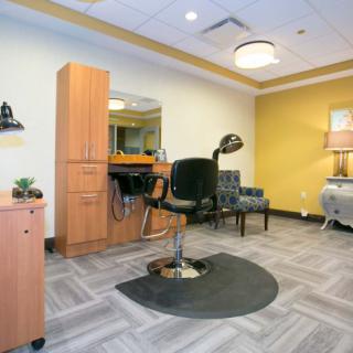 A clean and modern hair salon interior with chair and mirror setup.