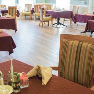 An empty dining room with tables and chairs neatly arranged.