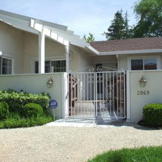 A modern house with a secure gated entrance and well-maintained garden.