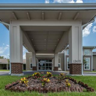 An inviting entrance to a modern building with a landscaped garden feature.