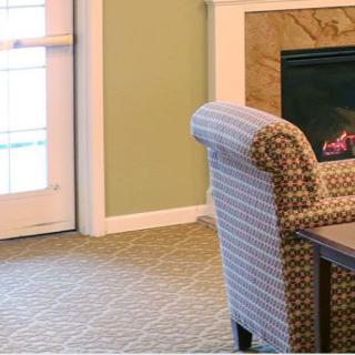 A cozy living room with an armchair and a fireplace.