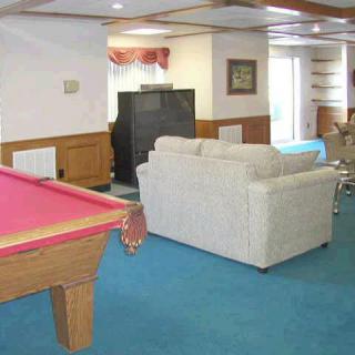 A cozy game room with a pool table and seating area.