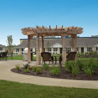 A landscaped garden with a wooden pergola and outdoor seating.