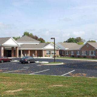 A suburban building with a parking lot and several parked cars.