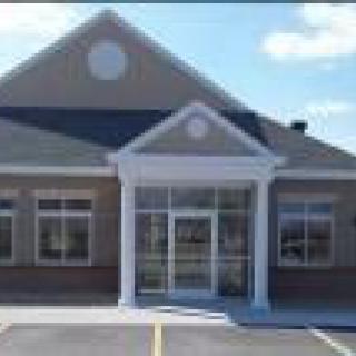 A commercial building with large windows and a central entrance.