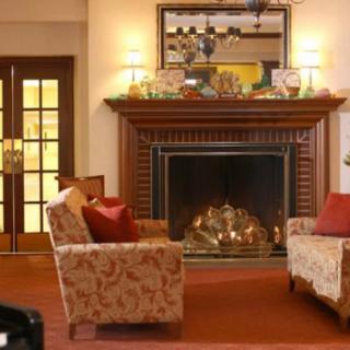 A cozy living room with a fireplace, comfortable armchairs, and elegant decor.