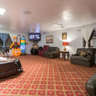 A cozy lounge area with multiple sofas, a television, and a patterned carpet.