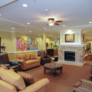 A cozy living room with comfortable seating, a fireplace, and colorful artwork on the wall.