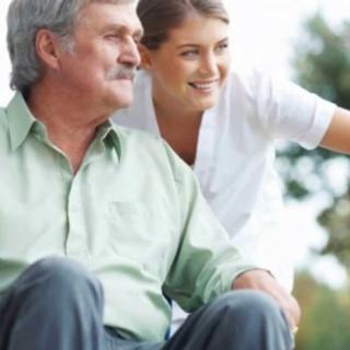 A caregiver providing support to an elderly man.