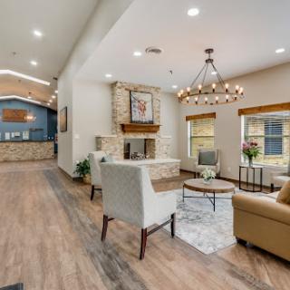 A beautifully designed modern living room featuring a cozy fireplace and elegant chandelier.