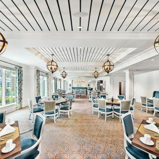 A modern dining room with elegant decor, featuring stylish tables, chairs, and unique lighting fixtures.