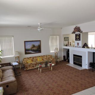A spacious and cozy living room featuring comfortable seating, a fireplace, and decorative elements.