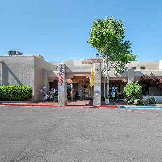 The exterior view of a hotel entrance with a clear blue sky.