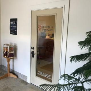 A view of an office entrance with a glass door and signage.