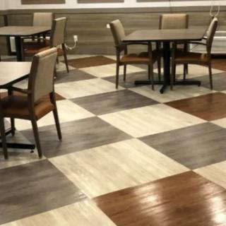 A dining area with a checkered floor pattern, featuring tables and chairs.